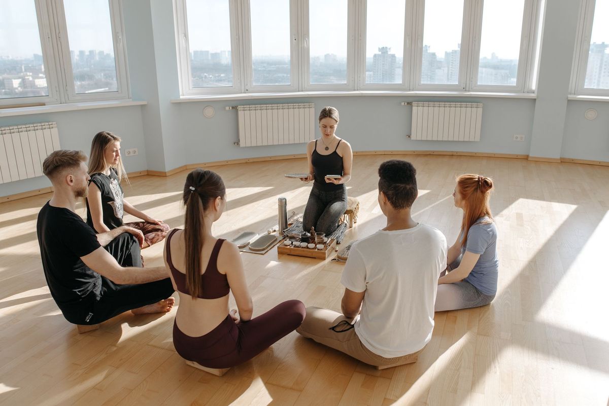 Maestra de Reiki con un grupo de alumnos sentados en círculo