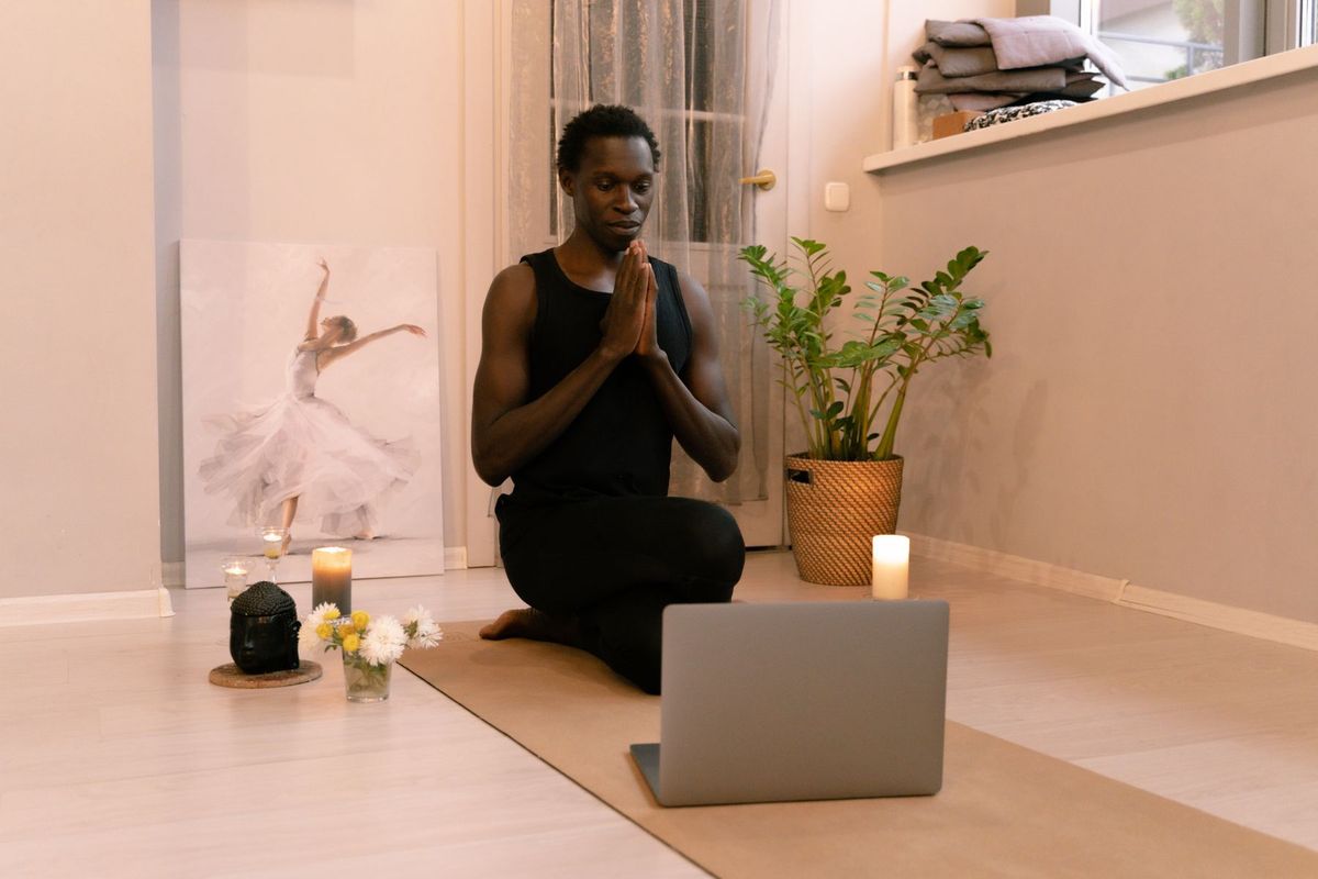 Persona meditando con las manos juntas junto a velas, práctica profunda de Reiki Nivel 3
